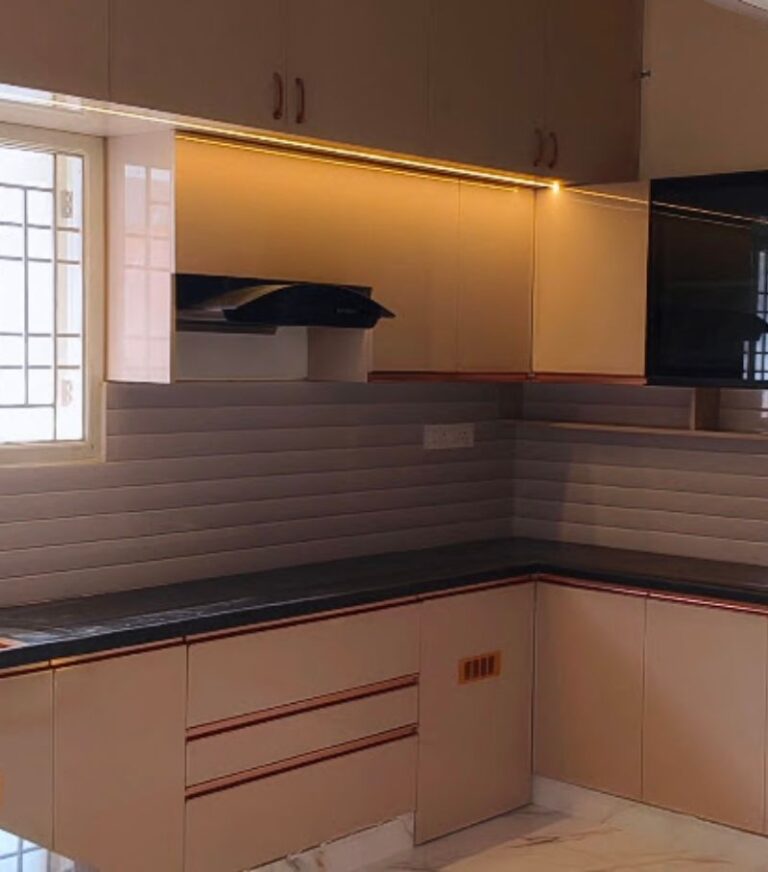 Beige modular kitchen with under-cabinet lights and chimney by House Decors, Chennai