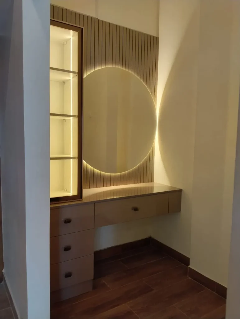 Dressing table with a round backlit mirror, fluted wall panel and a lit glass display unit, House Decors, Chennai