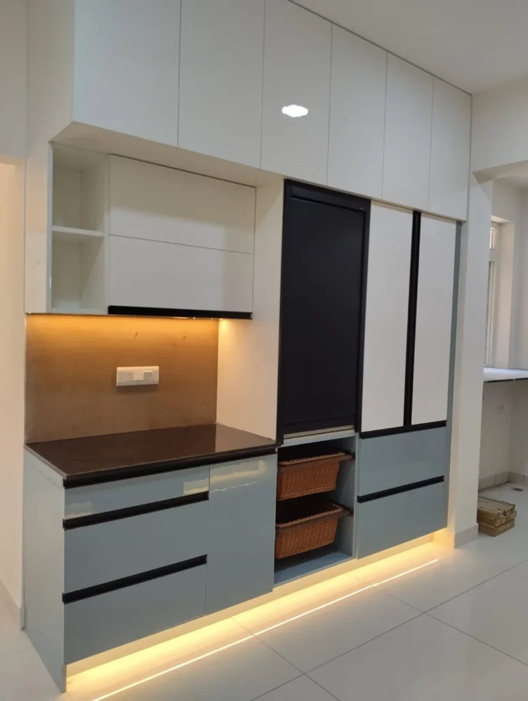 Kitchen unit with white loft cabinets, grey drawers, wicker baskets and LED lighting along the base, House Decors, Chennai