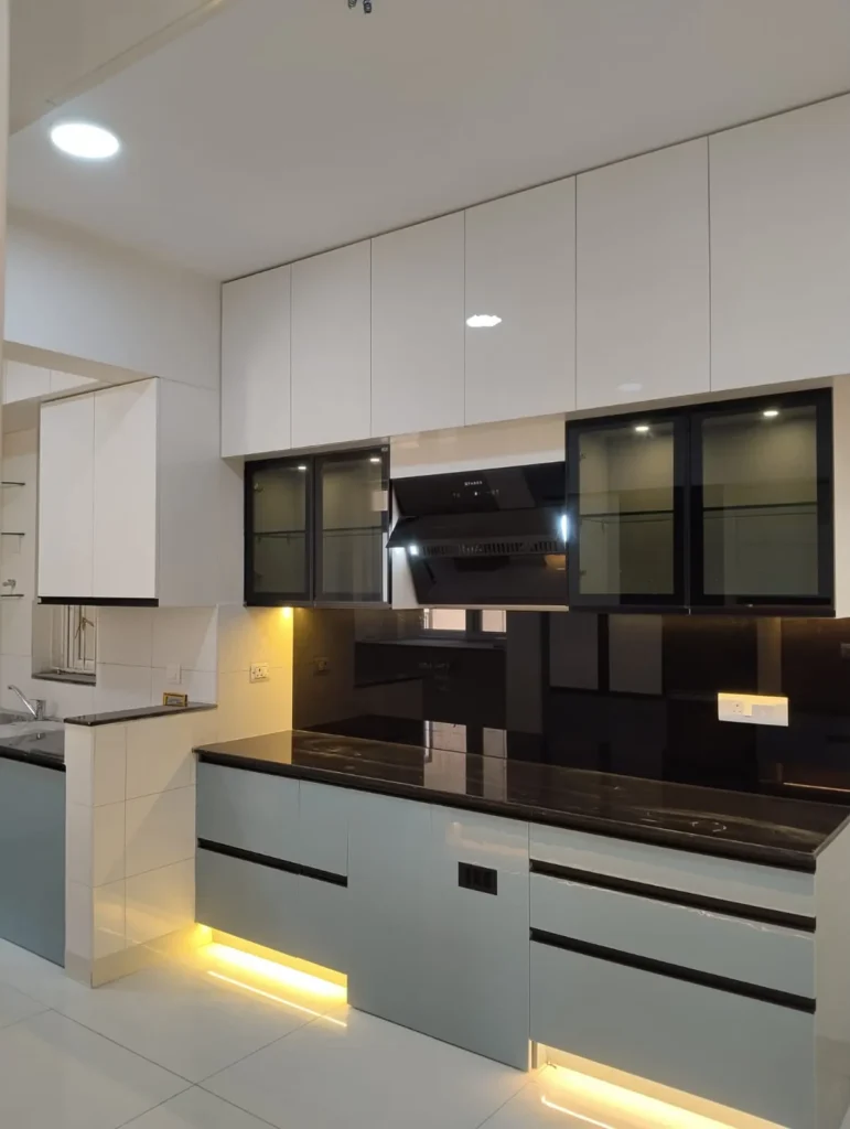 Modular kitchen with white upper units, black-framed glass shutters, a chimney, black glass backsplash and grey base drawers with LED lighting, House Decors, Chennai