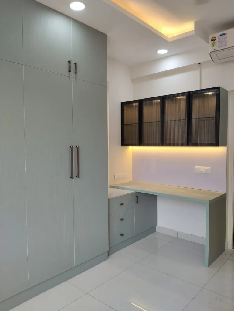 Sage-green wardrobe with loft and a study desk with fluted-glass wall cabinets and under-cabinet lighting, House Decors, Chennai