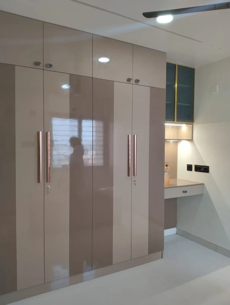 Two-tone beige gloss wardrobe with long copper-toned handles and a study nook with a lit glass-door cabinet, House Decors, Chennai