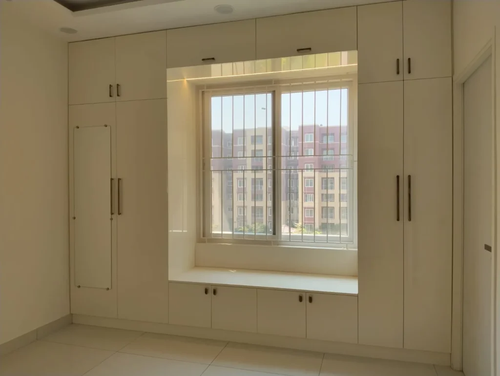 Built-in cream wardrobes with loft and a window seat with storage below, House Decors, Chennai